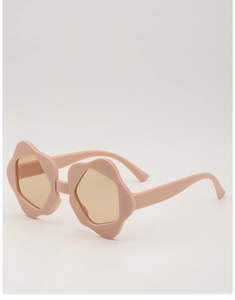 Detail view of flower-shaped kids sunglasses in matte pink with amber lenses