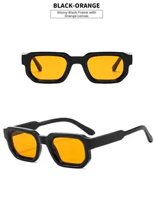 Detail view of vintage square sunglasses featuring black frames and orange tinted lenses