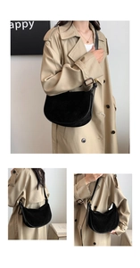 Detail of black suede crescent bag showing soft matte texture and gold buckle adjustment