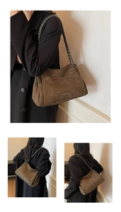 Detail of dark brown suede shoulder bag with chain strap and vintage texture