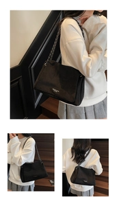 Close-up of the black suede shoulder bag with high-quality metal chain and brand logo