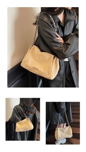 Detail of beige suede shoulder bag featuring a chic metal chain strap with a black coat