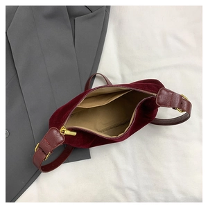 Interior view of burgundy velvet shoulder bag with khaki lining and golden hardware