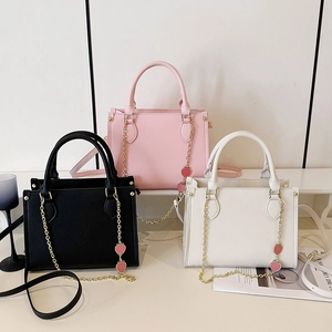 Trois sacs cabas minimalistes en noir, rose et blanc avec charms fraise et bandoulière