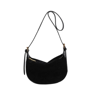 Macro shot of black suede hobo bag detailing the golden zipper and adjustable leather strap