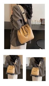 Detail of camel bucket bag with lychee texture and geometric jacquard wide strap