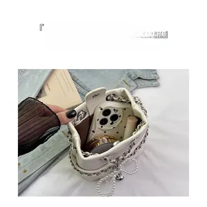 Interior view of white quilted bucket bag showing storage for phone and cosmetics