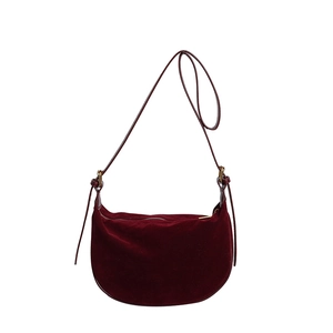 Detail of burgundy velvet crescent bag with gold zipper and adjustable shoulder strap