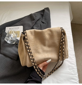 Detailed view of beige suede texture shoulder bag with elegant double chain strap design