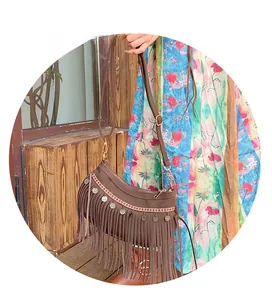 Détail du sac à bandoulière en daim marron bohème avec franges et breloques en pièces
