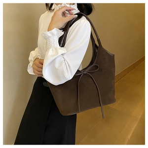 Detail of dark brown matte suede tote bag with a delicate decorative bow knot