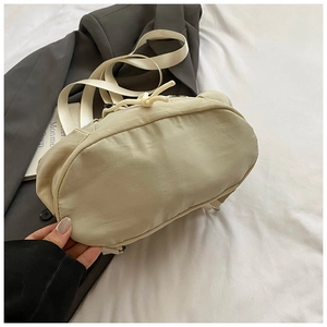 Detail view of the beige nylon casual backpack with drawstring and minimalist side profile