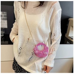 Detail der fuchsia-metallischen Mini-Tasche mit Spiraltextur und goldener Gliederkette