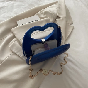 Binnenzijde van een hartvormige blauwe avondtas met goudkleurige ketting