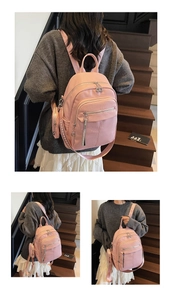 Pink pebbled leather backpack detail with multiple zip pockets and hanging coin pouch