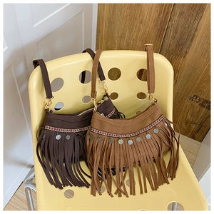 Détail de sacs bandoulière vintage à franges avec motifs tissés et accents métalliques