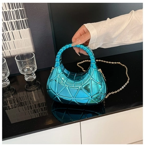 Détail du sac géométrique bleu métallisé avec panneaux 3D et bandoulière dorée