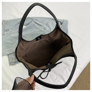 Interior view showing the large capacity, brown lining, and magnetic closure of the black bag