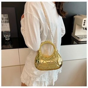 Détail du sac boîte doré géométrique avec poignée ronde et chaîne dorée
