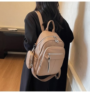 Detail of brown faux leather backpack with pebble texture and mini round coin purse
