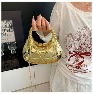 Gros plan du sac croissant doré avec motif géométrique et bandoulière en chaîne