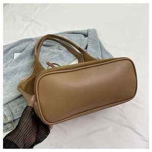 Detail of large brown tote bag showing smooth leather and suede patchwork texture