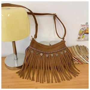 Gros plan du sac à franges en daim marron avec broderie ethnique et breloques de pièces