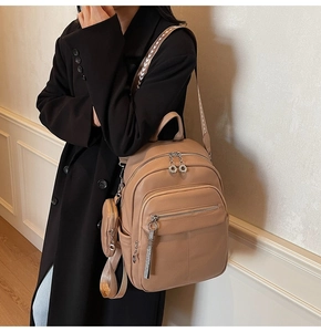 Detail of soft lychee leather backpack with wide woven strap and metal zipper