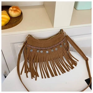 Détail du sac bandoulière en daim marron avec sangle tissée ethnique et longues franges