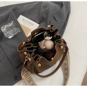 Interior detail of retro brown bucket bag showing large capacity and geometric strap
