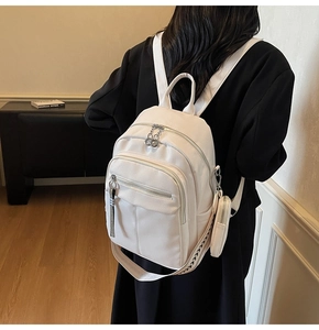 Close-up of white lychee-patterned backpack featuring a detachable small coin purse
