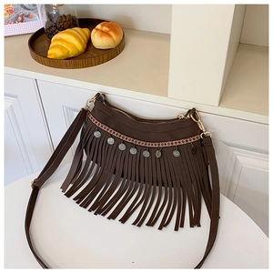 Détail d'un sac punk rétro avec de longues franges et des pièces ethniques