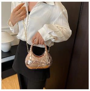 Détail du sac géométrique or rose avec chaîne métallique et poignée ronde rigide
