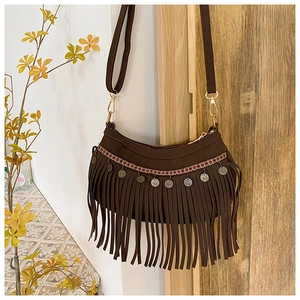 Détail du sac bohème en daim marron avec tissage ethnique et breloques de pièces argent