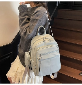 Detail of light mint green faux leather backpack with side pocket and round coin purse