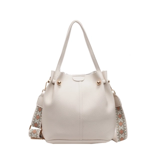 Close-up of white pebble leather bucket bag featuring a colorful geometric strap