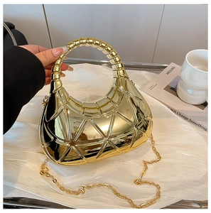 Dettaglio di una borsa dorata in acrilico con trama geometrica 3D e manico circolare