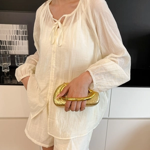 Elegant white two-piece set with long sleeve shirt, shorts and gold woven metal handle bag
