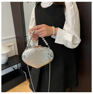 Detailed shot of silver shell evening bag with water ripple texture and beaded handle