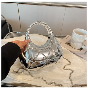 Dettaglio ravvicinato della borsa hobo argento con trama geometrica ed effetto specchio