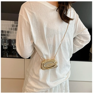 Detailed view of a gold metallic oval layered clutch bag with thin chain strap