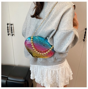 Detail view of colorful gradient shell texture acrylic clutch bag with golden chain strap