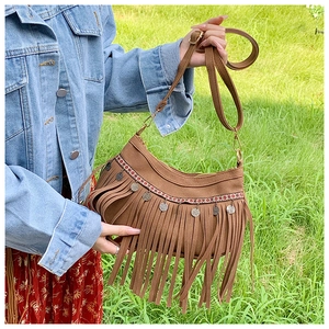 Détail d'un sac bandoulière vintage marron avec franges et broderies de style ethnique