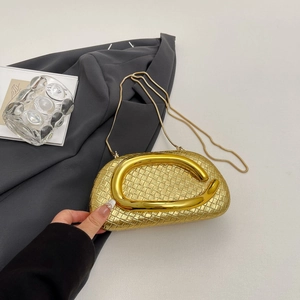 Detail of gold woven semi-circle clutch with fish-shaped metal handle and chain strap