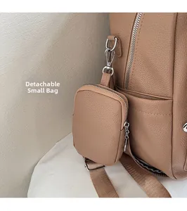 Detalle de bolsa pequeña desmontable con gancho plateado en mochila de cuero marrón