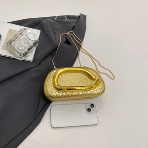 Chic gold woven evening bag with round metal handle and snake chain on minimalist background