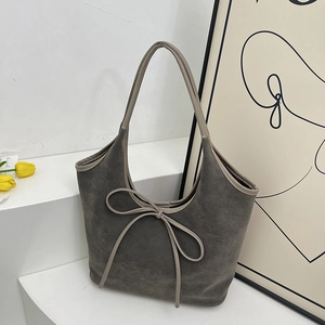 Dark grey faux suede tote bag with elegant bow detail and light grey handles