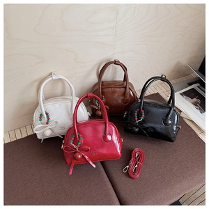Collection of chic glossy mini handbags in four colors with charms and detachable straps