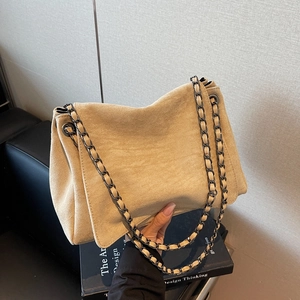 Minimalist beige suede underarm shoulder bag with metal chain strap and large eyelets