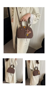 Detail of dark brown shell bag showing suede texture and detachable decorative charms